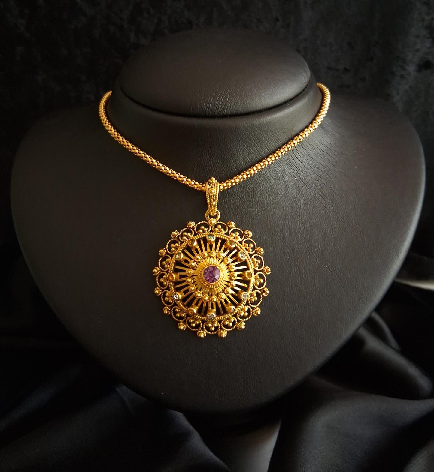 Medalha tipo filigrana com pedra lilas ,em ouro